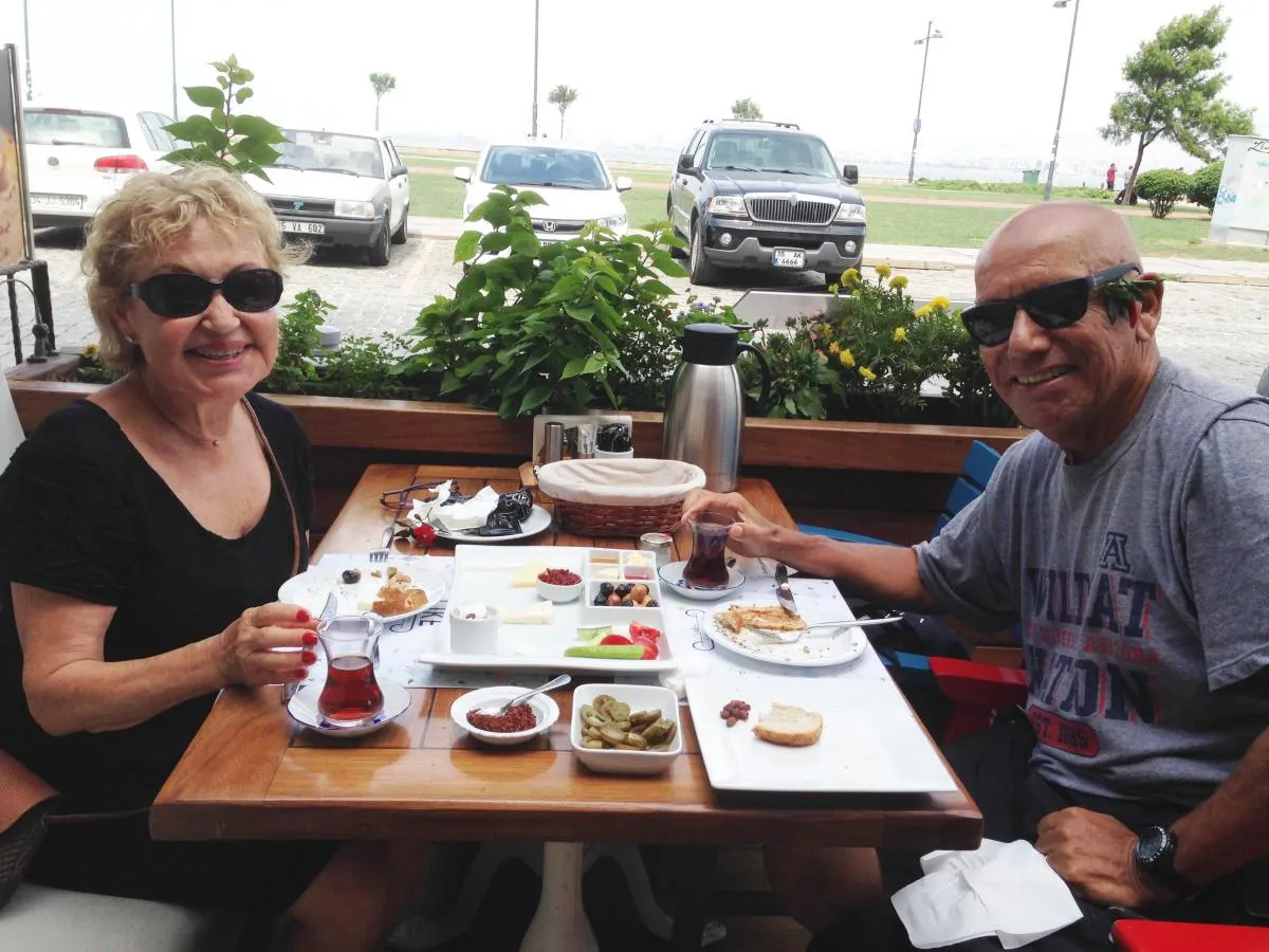 Rich and Bahar Delgado sitting at table with food, eating